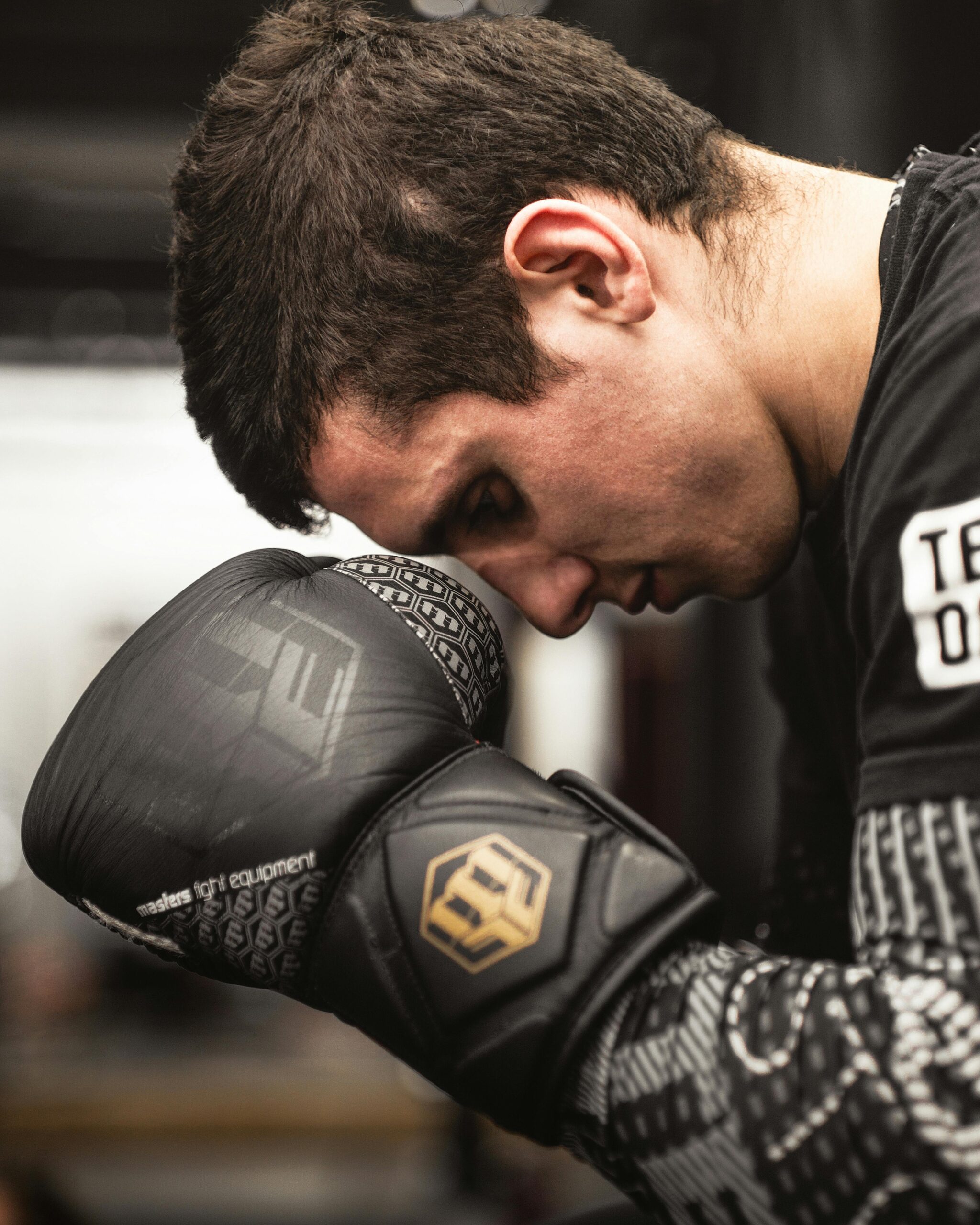 A determined boxer with gloves, preparing for an intense training session indoors.